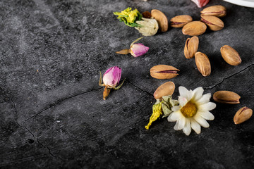 Pistachios and margarite flower on a piece of marble