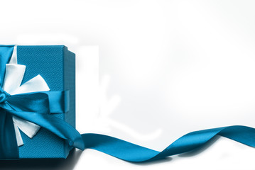 Blue gift box with bow and ribbon on a white background, isolated image