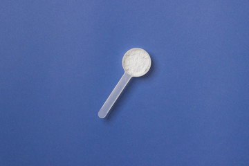 measure spoon on blue colored paper background