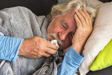 New coronavirus CoVid-19 outbreak situation with pandemic epidemic warning - adult caucasian senior old man with fever symptoms like illness cold seasonal influenza - people and virus concept - obrazy, fototapety, plakaty