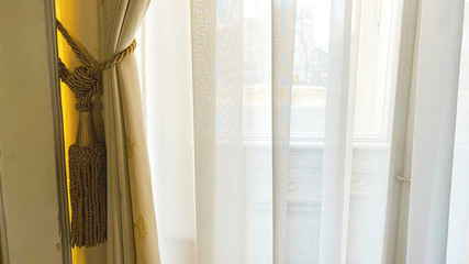 Curtain with warm sunlight close-up with decorative elements.