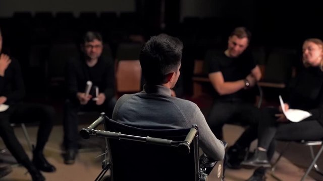 a man in a wheelchair tells his story while sitting in a circle with people