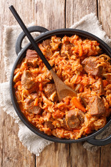 Cabbage stew with beef meat, tomatoes, carrots closeup in a plate. Vertical top view