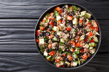Healthy colored quinoa, avocado, pepper, tomatoes and black beans close-up in a plate. Horizontal top view