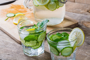 Detox water with lemon and cucumbers in glass 