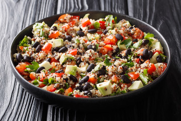 Healthy colored quinoa, avocado, pepper, tomatoes and black beans close-up in a plate. horizontal