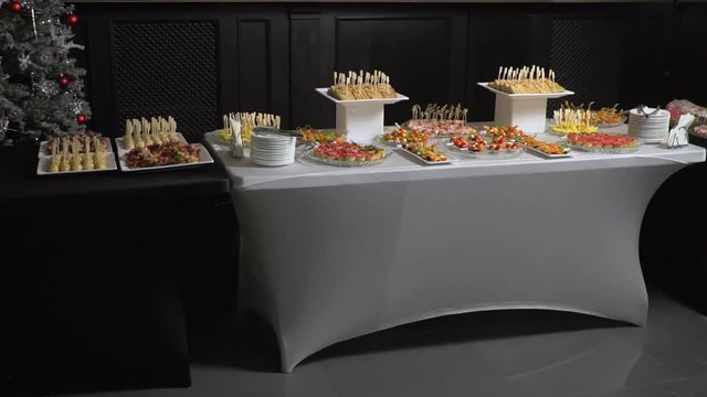 A table with catering is covered with a black cloth.