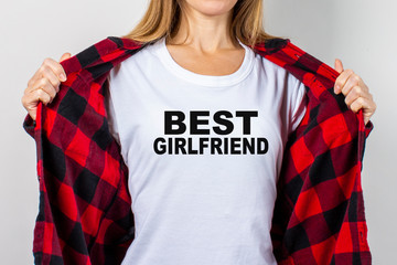 Young woman in a red shirt and white t-shirt on a white background. T-shirt text added Best...