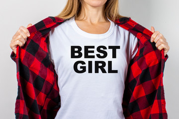 Young woman in a red shirt and white t-shirt on a white background. T-shirt text added Best girl....