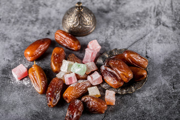 Turkish lokum with oriental dates inside an ethnic style saucer in the center of marble