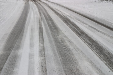 Naklejka premium car tracks on the road covered with fresh snow