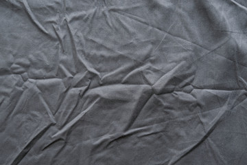 Abstract pattern of a gray crumpled bed sheet in bedroom. Gray wrinkled fabric texture rippled surface, Close up bed sheet in the bedroom.