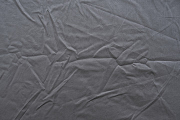 Abstract pattern of a gray crumpled bed sheet in bedroom. Gray wrinkled fabric texture rippled...