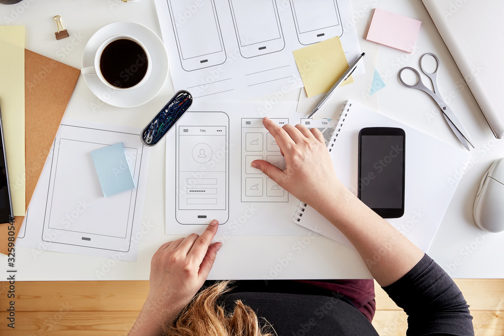 Poster young ux graphic designer planning out the structure of a mobile application. wireframing stage of a