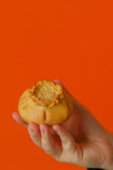 Gubadia - Tatar traditional dish. Gubadia in hand on an orange background. Traditional Tatar Cuisine. 