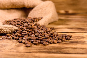 Sackcloth and scattered coffee beans on wooden table