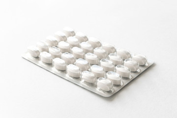 White pills tablets in package on a white background. Capsule pills in plastic pack.