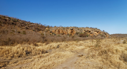 Volcanic Cliffs on the sloping edge of a South African Inselberg, rising abruptly out of the Dry Grassy Plain on the Madikwe Game reserve.