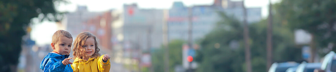 children cross the road / boy and girl small children in the city at the crossroads, car, transport