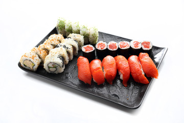Sushi. Traditional Japanese sushi. Appetizing set on a black plate on a white background