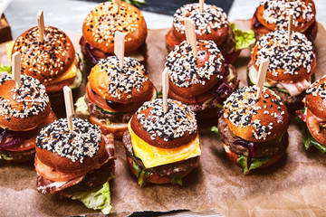 A large set of many hamburgers, cheeseburgers laid out on the table. Seth fast food. Food background, copy space.