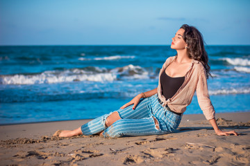 Fototapeta na wymiar a beautiful girl stand at the beach looking at the sea