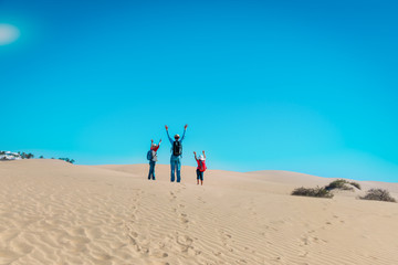 happy family in dunes of Maspalomas, Spain