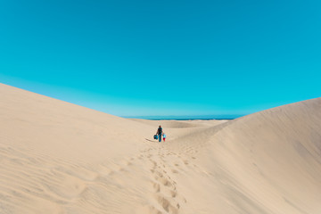 Fototapeta na wymiar mother and little daughter walk in dunes of Maspalomas, Spain