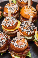 A large set of many hamburgers, cheeseburgers laid out on the table. Seth fast food. Food background, copy space.