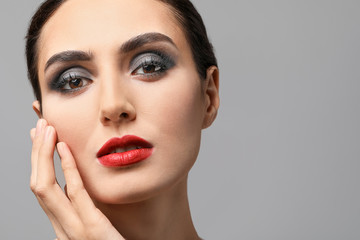 Fototapeta premium Young woman with beautiful makeup on grey background