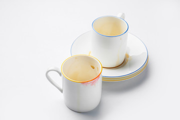 Dirty empty cups with saucer on white background