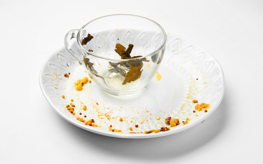 Dirty empty cup with plate on white background