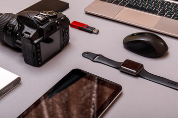 Digital camera, usb with external harddisk or battery and equipment of the professional photographer on grey paper background. Designer workplace concept.