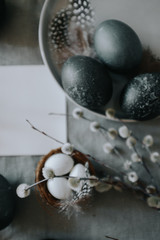 Easter table setting with gray textile napkin, quail and chicken eggs, blossom branch and mock up easter card. 