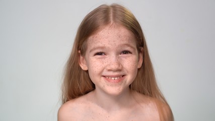 smiling little Girl with blond hair, freckles is 