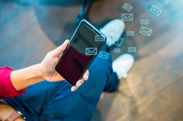 A man in redshirt using a smartphone, reading a letter, mobile device. sitting at the coffee shop hipster lifestyle People and technology concepts