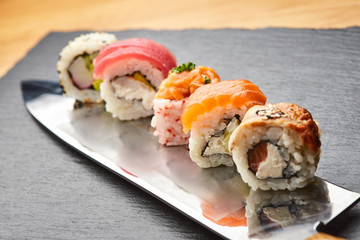 Various kinds of sushi roll set served on a knife blade. Japanese food