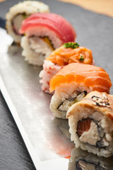 Various kinds of sushi roll set served on a knife blade. Japanese food