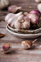 The bulbs of garlic, slice, on ceramic plate on a wooden table