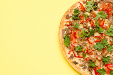 Hot delicious pizza on summer yellow background with a copy space.