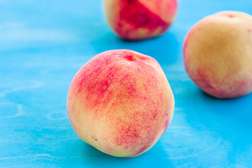 fresh peaches on a blue wooden background