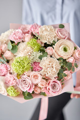 European floral shop. Beautiful bouquet of mixed flowers in womans hands. the work of the florist at a flower shop. Delivery fresh cut flower.