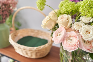 Education in the school of floristry. Master class on making bouquets. Summer bouquet in a wicker basket.. Learning flower arranging, making beautiful bouquets with your own hands. Flowers delivery