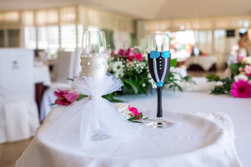 Close-up of two glass of champagne decorated in a suit of a groom and a bride.