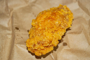 Chicken wings fried in breadcrumbs on a grey paper background. Close up.