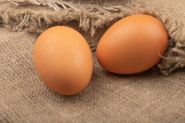 Chicken eggs on a background of rough homespun fabric. Homemade preparations, rustic treats. Close up.