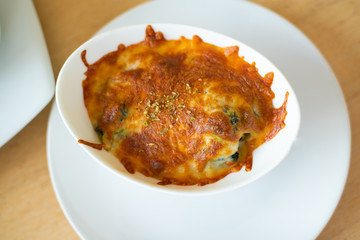 Baked Spinach with Cheese in white bowl.