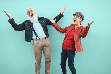 Happy senior couple having fun together outdoor - Retired man and woman celebrating crazy moments - Elderly people lifestyle and love relationship concept