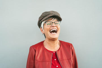 Happy senior woman laughing outdoor - Trendy mature person having fun during retired time - Elderly...