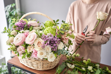 Woman florist creating beautiful bouquet in flower shop. Work in flower shop. Flowers delivery. - obrazy, fototapety, plakaty